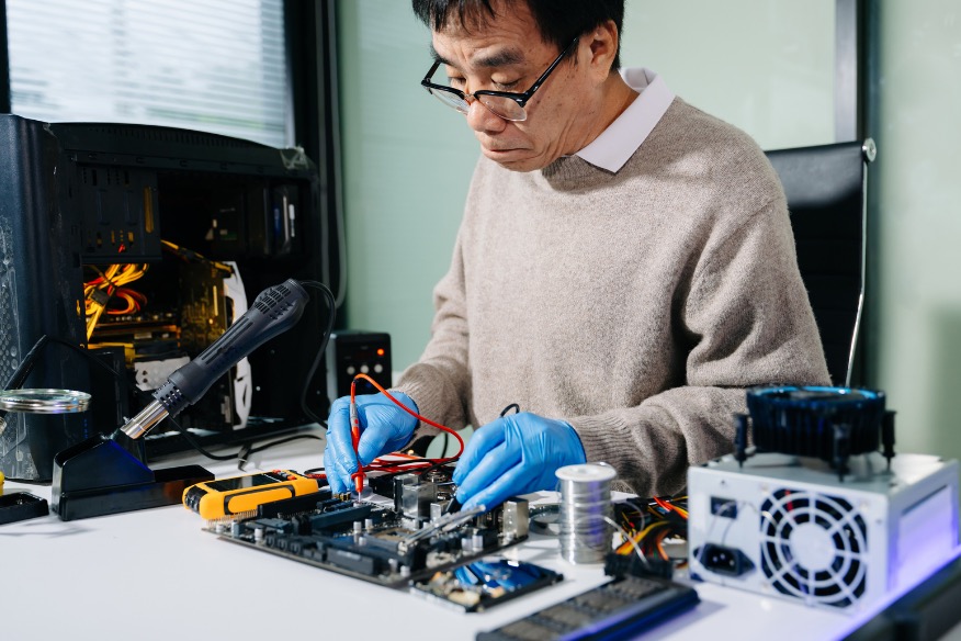 Computer repair technician diagnosing desktop PC hardware in Auckland